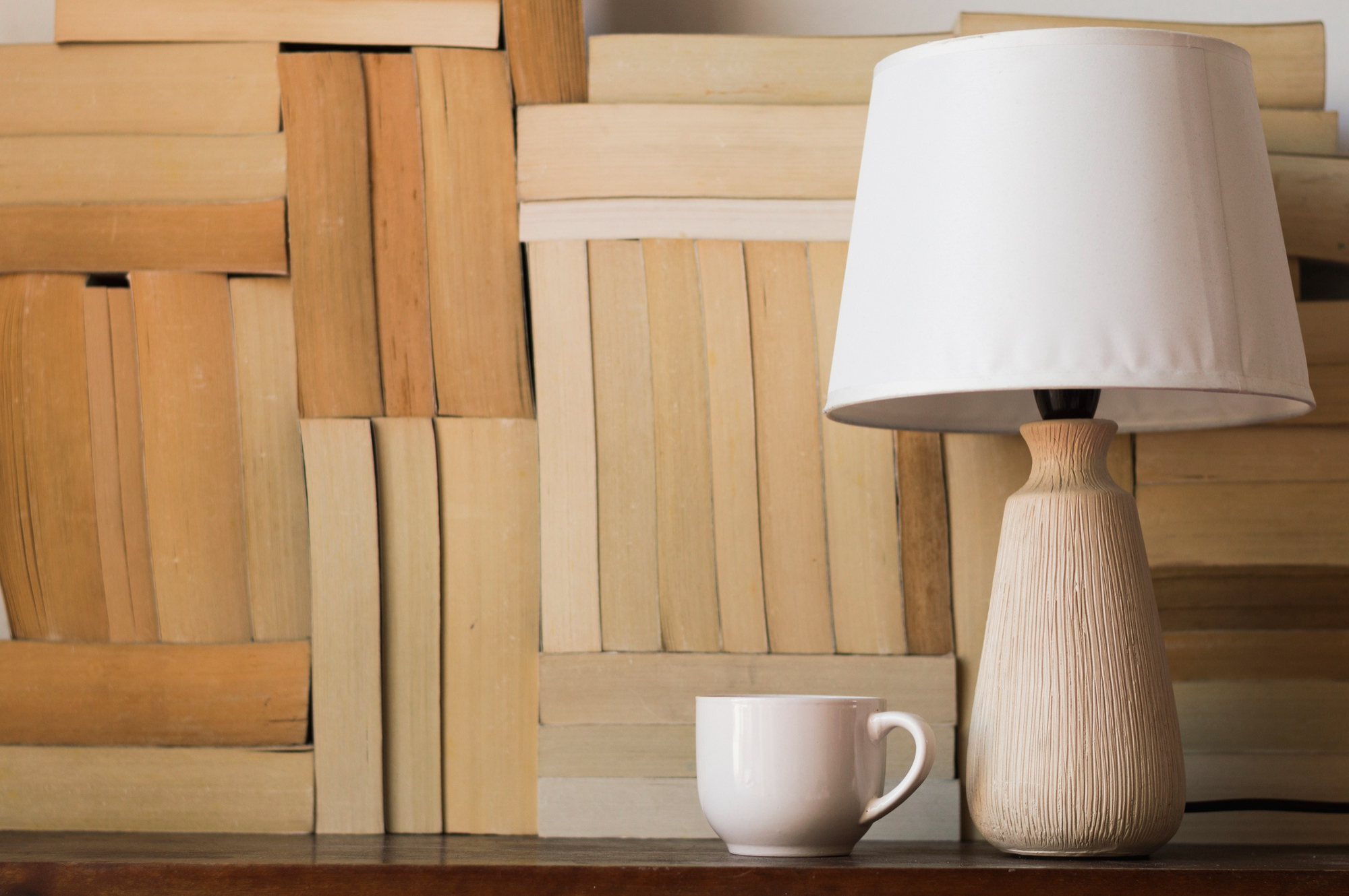 A warm lamp illuminates a coffee cup resting on a table, creating a relaxing atmosphere.