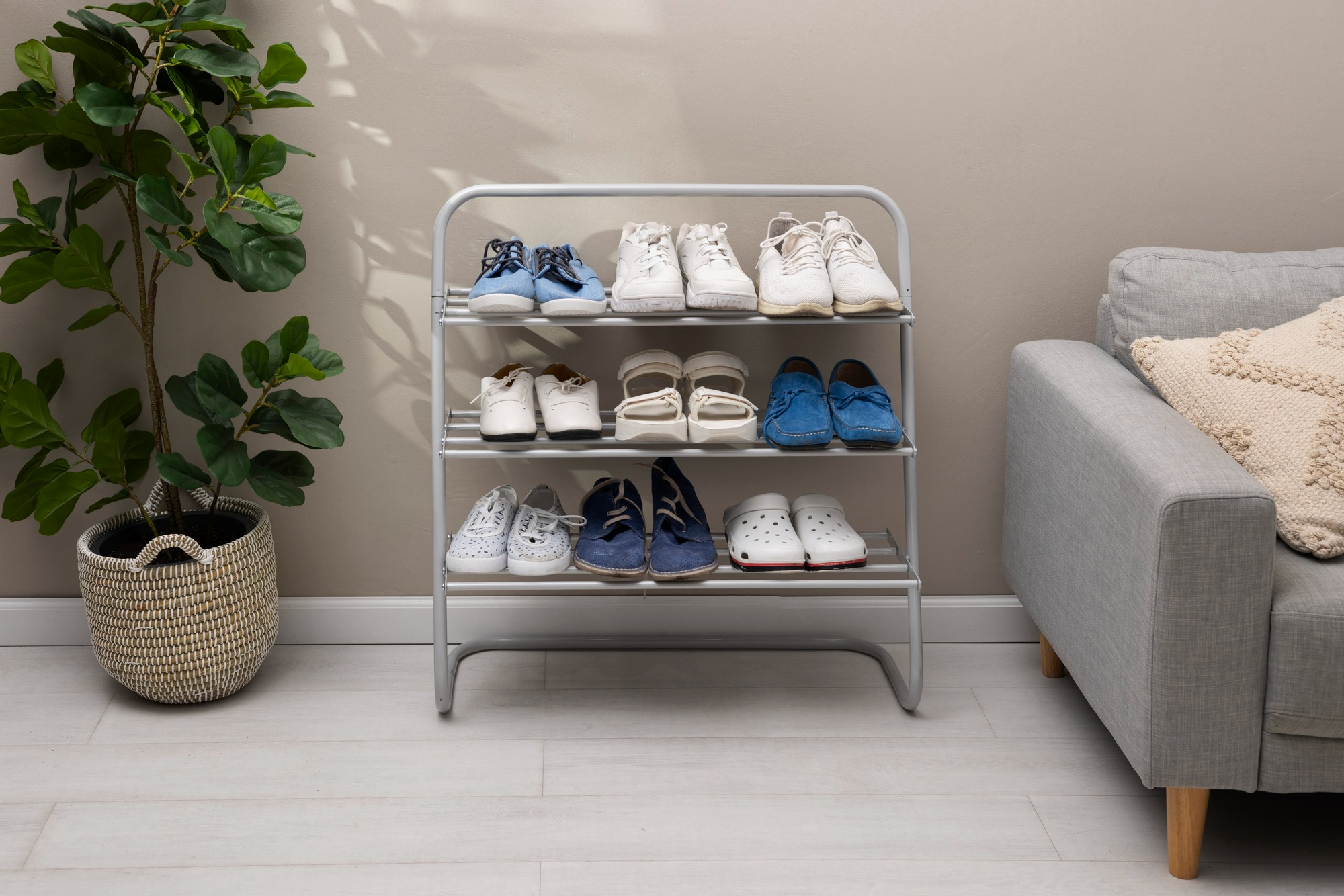 shoe rack displaying various shoes alongside a small potted plant for decorative touch.