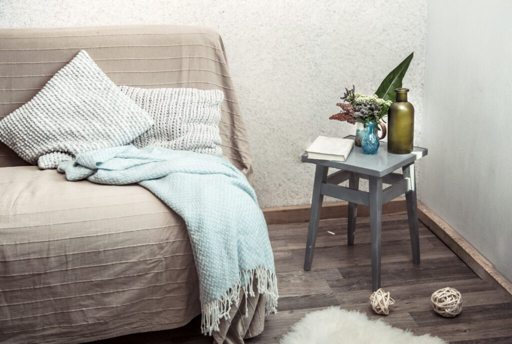 Home sofa with objects of cozy decor in the living room