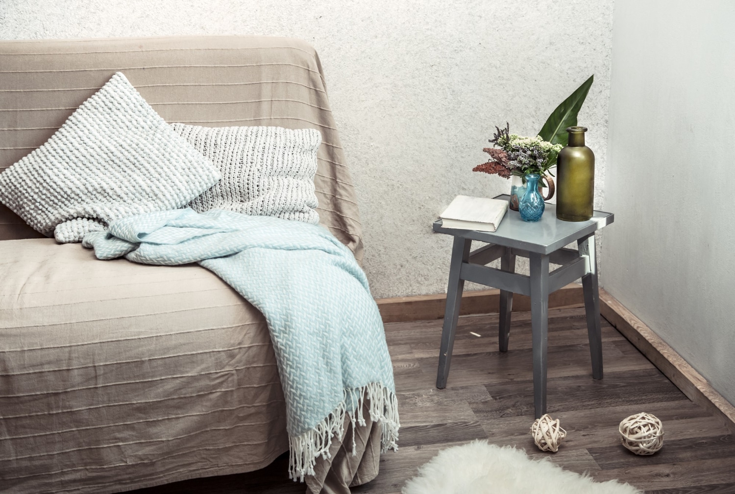 Home sofa with objects of cozy decor in the living room