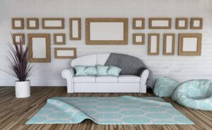 A cozy living room with a white sofa, decorative cushions, and multiple framed pictures on a white brick wall.