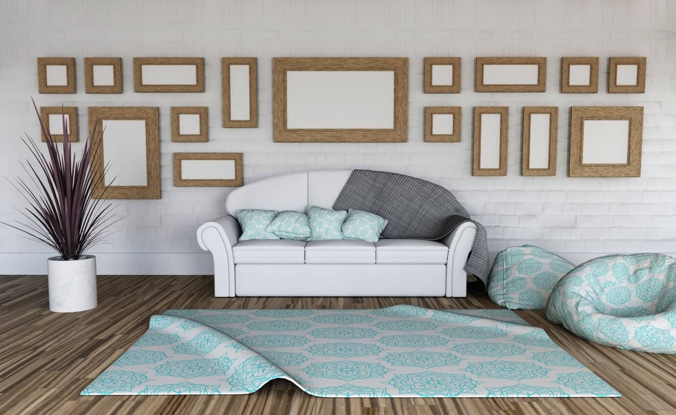 A cozy living room with a white sofa, decorative cushions, and multiple framed pictures on a white brick wall.