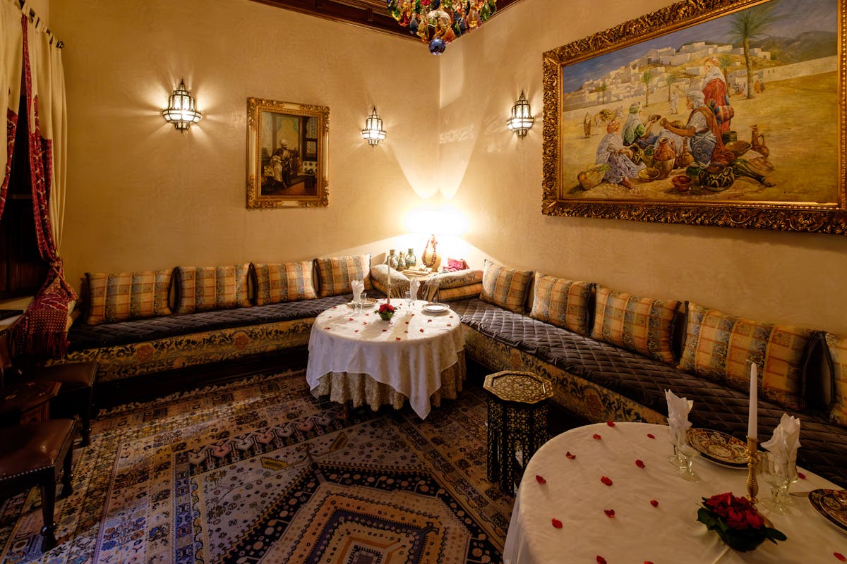 Interior of a traditional Middle Eastern restaurant with ornate decor and patterned textiles.