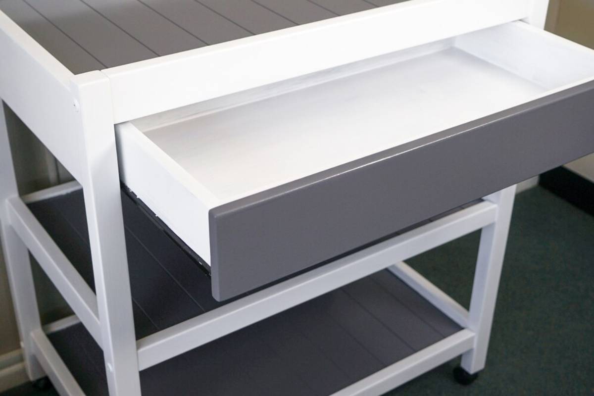 Closeup of a modern white table with a drawer under the lights