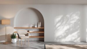 Modern minimalist living room with arched shelving, a chair, floor lamp, and shadow patterns on the wall.