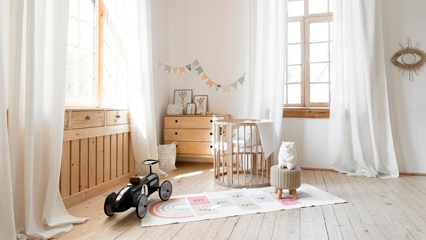 Bright and airy nursery with natural wood furniture, large windows, and playful decor.